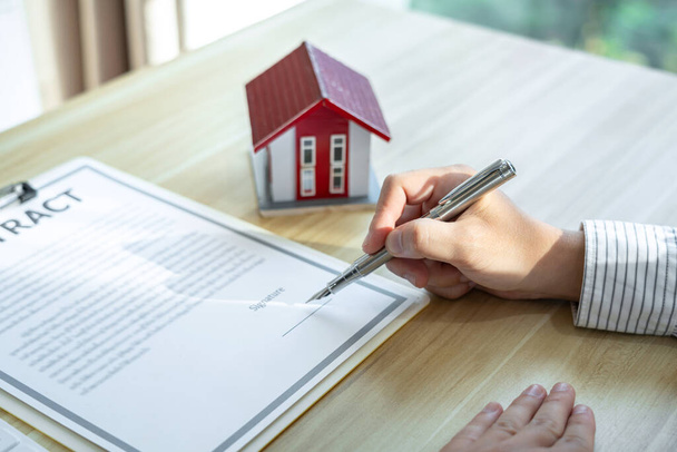 Estate broker agent presenting and consult to customer to decision making sign insurance form agreement, home model, concerning mortgage loan offer. - 写真・画像