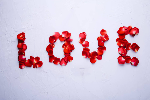 Слово Любов з пелюсток троянд на сірому фоні
 - Фото, зображення