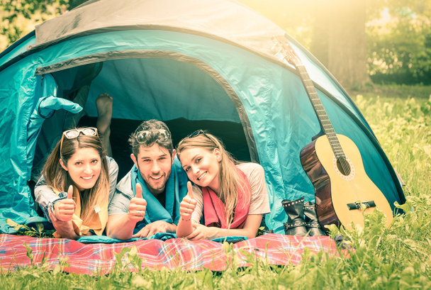 Grupo de melhores amigos com polegares para cima se divertindo acampar juntos - Conceito de juventude despreocupada e liberdade ao ar livre na natureza durante as férias - Vintage olhar filtrado
 - Foto, Imagem