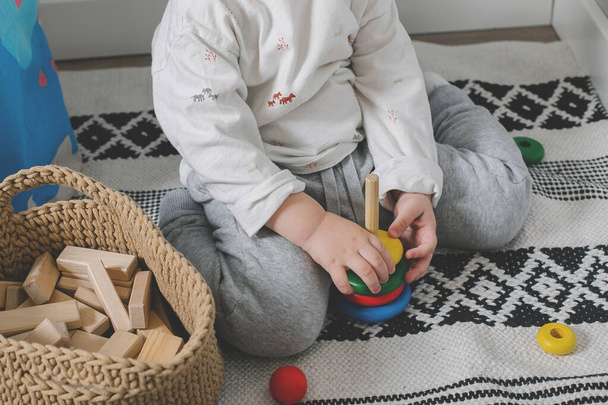 Little baby boy and developmental toys at home. Montessori for child development. Close-up - 写真・画像