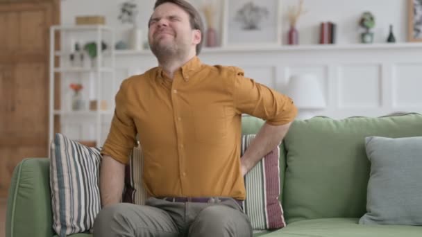 Jeune homme ayant mal au dos sur le canapé  - Séquence, vidéo