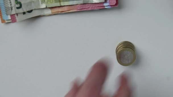 Hand eines europäischen Mannes, der Euro-Banknoten und Euro-Münzen auf weißem Schreibtisch mit 10-, 20- und 50-Euro-Banknoten als Einkommen für Finanzinvestitionen und Kapital des Crowdfunding-Gehaltsstapelhandels zählt - Filmmaterial, Video