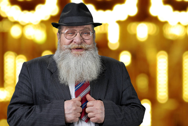 Fröhliche Senior-Geschäftsmann steht auf goldenen Bokeh Lichter Hintergrund. - Foto, Bild