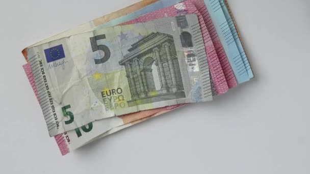 Hand of European man counting euro bank notes and euro coins on white desk with 10, 20 euro and 50 euro banknotes as income for financial investment and capital of crowd funding salary stack trade - Footage, Video