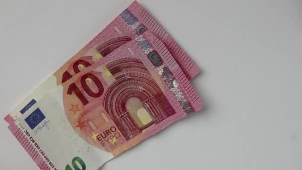Eurooppalaisen miehen käsi, joka laskee euroseteleitä ja eurokolikoita valkoiselle pöydälle 10, 20 ja 50 euron euroseteleillä tuloksi rahoitussijoituksiin ja joukkorahoituksen pääomaksi palkkapinokauppa - Materiaali, video