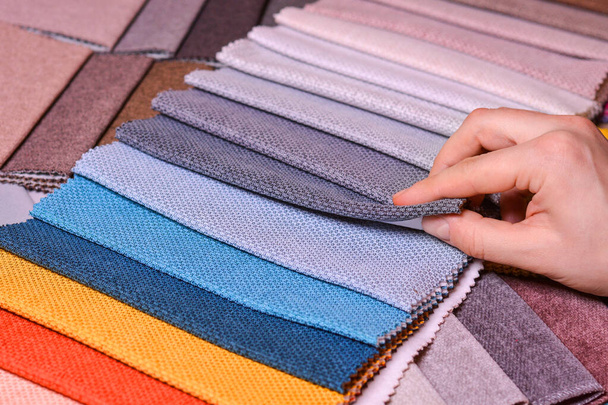 Klient patrzy i wybiera kolor tkaniny, który lubi, wybiera materiał z tkanin do swojej nowej sofy. - Zdjęcie, obraz