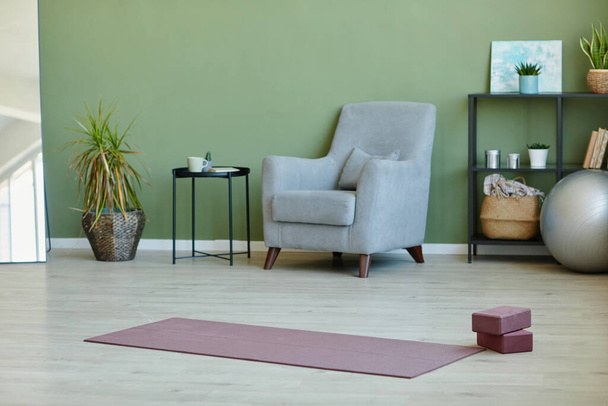 Intérieur du vaste salon avec tapis de yoga et blocs sur le sol - Photo, image
