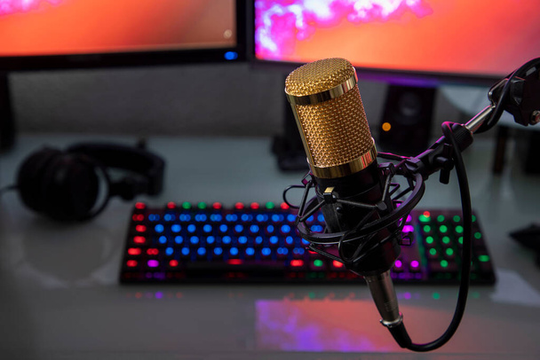 Professional microphone with gamer workstation in the background and headphones - Photo, Image