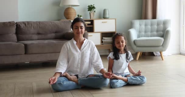 Indian mom and little daughter do meditation practice at home - Séquence, vidéo