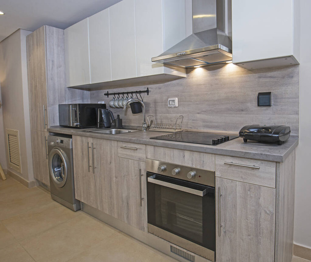 Interieur inrichting met moderne keuken en apparatuur in luxe appartement showroom - Foto, afbeelding