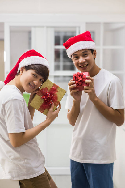 Happy LGBT young Asian couple show Valentine or Christmas gifts. Happy gay men exchange present. Same sex family at home. - Foto, imagen