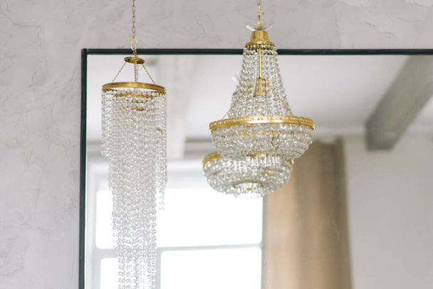 Large crystal glass chandelier with gold inserts in the living room - Fotoğraf, Görsel