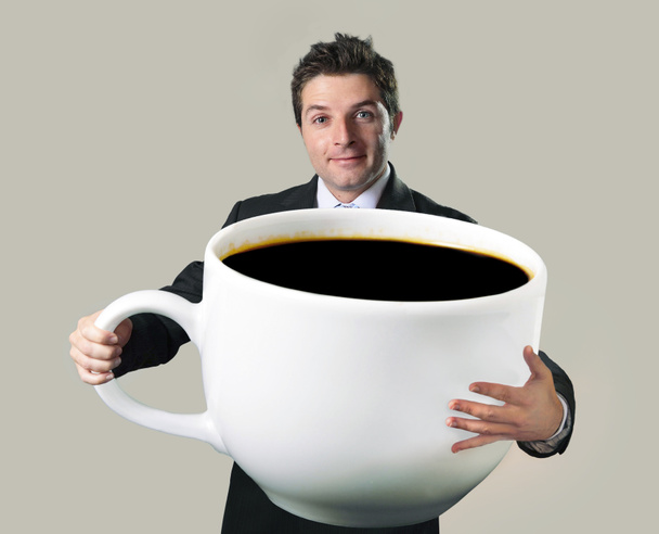 heureux homme d'affaires tenant drôle énorme tasse surdimensionnée de noir cof
 - Photo, image