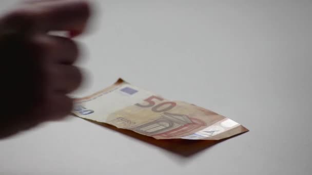 Hand van de Europese man die eurobankbiljetten en euromunten op een wit bureau telt met bankbiljetten van 10, 20 en 50 euro als inkomsten voor financiële beleggingen en kapitaal van crowdfunding salaris stack handel - Video