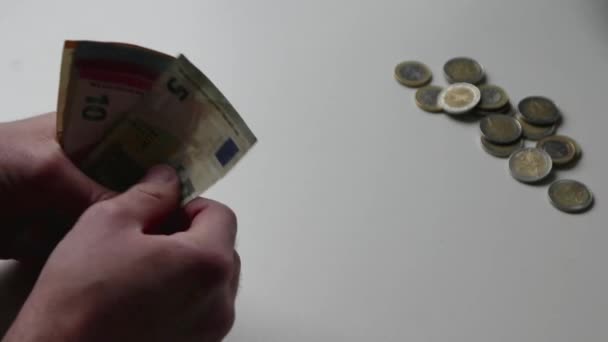 Mano dell'uomo europeo che conta banconote in euro e monete in euro su banco bianco con banconote da 10, 20 e 50 euro come reddito per gli investimenti finanziari e capitale per il finanziamento collettivo - Filmati, video