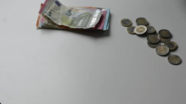 Hand eines europäischen Mannes, der Euro-Banknoten und Euro-Münzen auf weißem Schreibtisch mit 10-, 20- und 50-Euro-Banknoten als Einkommen für Finanzinvestitionen und Kapital des Crowdfunding-Gehaltsstapelhandels zählt - Filmmaterial, Video
