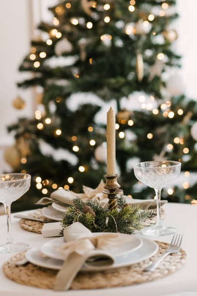 Stylish bright interior of the living room with a Christmas tree and a festive table - Valokuva, kuva