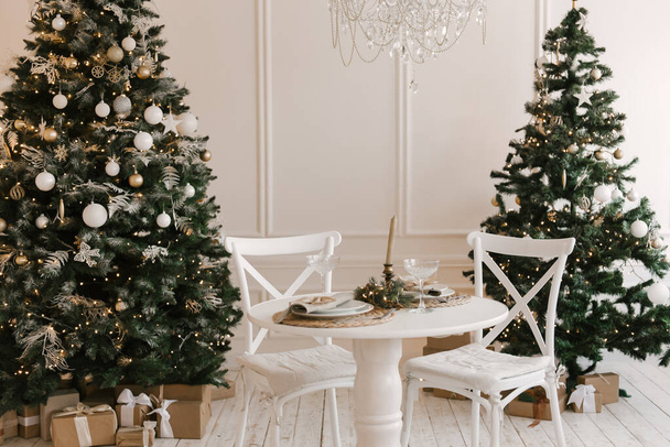 Stylish bright interior of the living room with a Christmas tree and a festive table - Foto, immagini