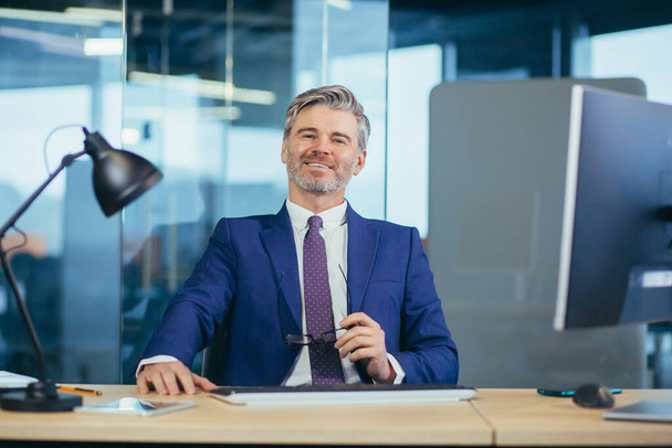Portrait of successful seo boss, businessman at work, working on computer in modern office, looking at camera, happy and smiling - Фото, зображення