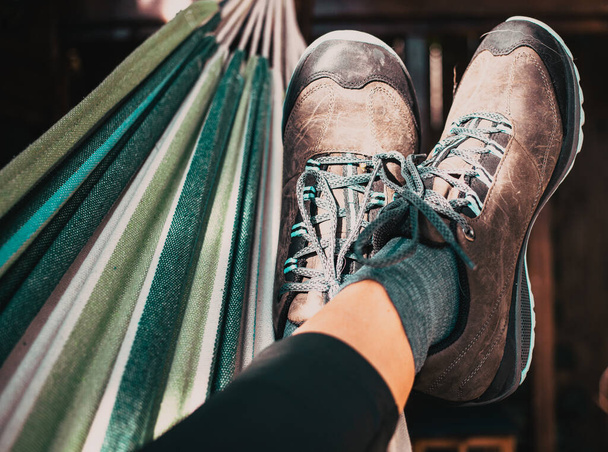 mujer en zapatos de senderismo relajante en hamaca después de trekking - Foto, Imagen