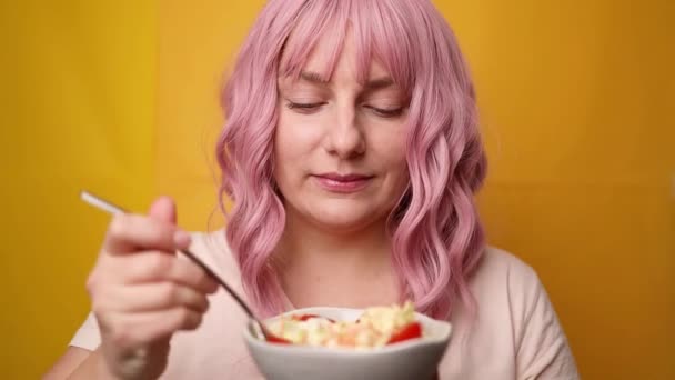 Gyönyörű kaukázusi nő eszik saláta izolált sárga alapon, egészséges étrend fogyás, vitaminok - Felvétel, videó