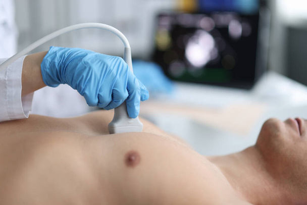 Doctor performs chest ultrasound on man in hospital closeup - Photo, Image