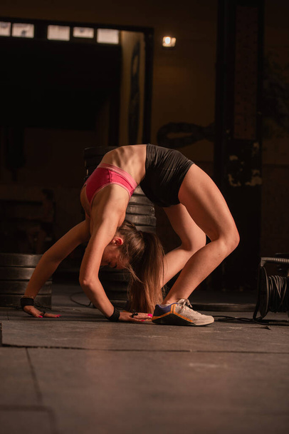 mooi fit meisje is buigen en stretching haar terug in de sportschool - Foto, afbeelding
