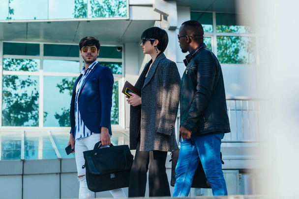 Grupa trzech wieloetnicznych kolegów biznesowych rozmawia podczas spaceru na zewnątrz na przerwie - Zdjęcie, obraz