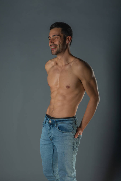 Studio portrait of a shirtless sexy man with abs in denim blue jeans - Foto, Imagem