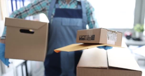 Uniformed courier δίνοντας κίτρινο φάκελο και κουτί από χαρτόνι στον πελάτη closeup 4k ταινία - Πλάνα, βίντεο