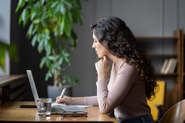 Estudante focado mulher observando ideias de seminário on-line palestra ou oficina sentar na frente do laptop - Foto, Imagem