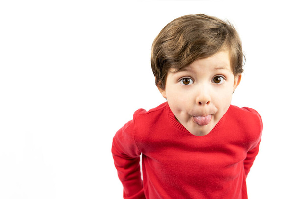 Chico sacando su lengua sobre un fondo blanco - Foto, imagen