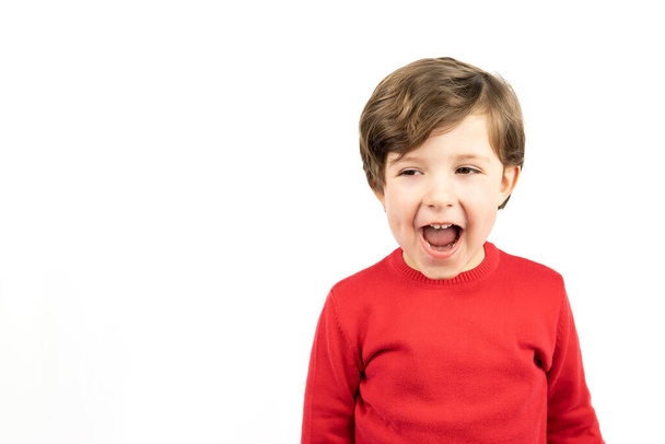 Niño en suéter rojo sonriendo sobre fondo blanco. - Foto, imagen