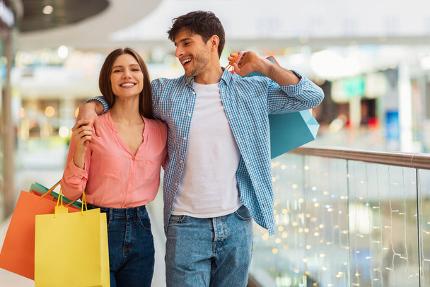 Ευτυχισμένο ζευγάρι αγκαλιάζει κάνει ψώνια περπατώντας μαζί στην υπεραγορά - Φωτογραφία, εικόνα
