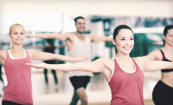 group of smiling people exercising in the gym - 写真・画像