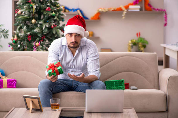 Young man celebrating Christmas at home alone - Фото, изображение