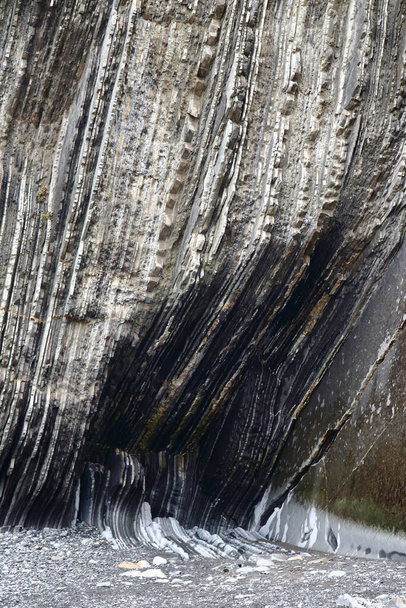 Szczegóły szalonych formacji skalnych (zjawisk geologicznych zwanych flysch) można znaleźć na plaży Itzurun, miejscu, gdzie nakręcono materiał z gry na tronie, położonym w wiosce Zumaia, Kraj Basków, Hiszpania. - Zdjęcie, obraz