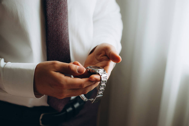 businessman checking time on his wrist watch, man putting clock on hand,groom getting ready in the morning before wedding ceremony. - Fotoğraf, Görsel