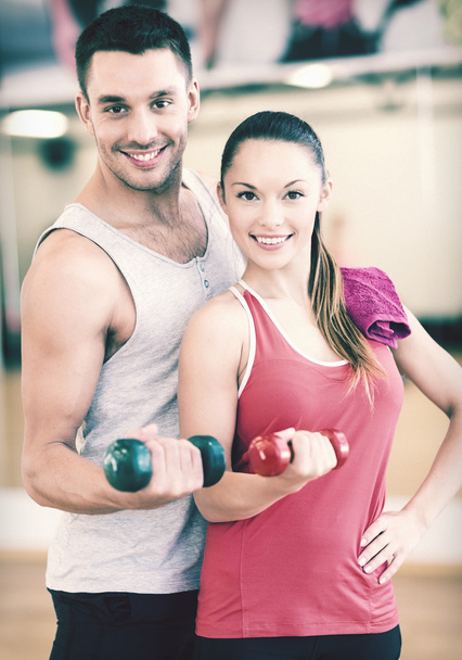 two smiling people working out with dumbbells - Фото, зображення