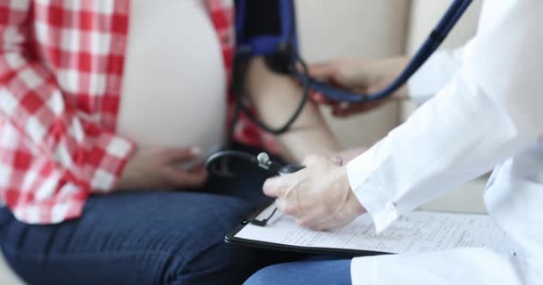 Γιατρός μέτρησης της αρτηριακής πίεσης σε έγκυο γυναίκα closeup 4k movi - Πλάνα, βίντεο