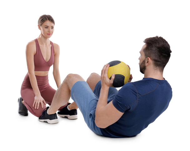 Athletic couple doing exercise with medicine ball on white background - Foto, afbeelding