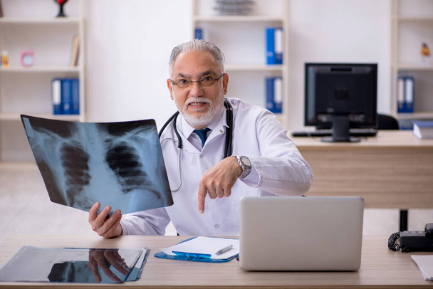 Oude mannelijke arts radioloog werkzaam in de kliniek - Foto, afbeelding