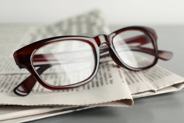 Newspapers and glasses on grey table, closeup - Photo, Image