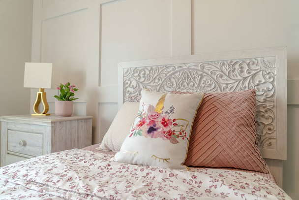 Łóżko pojedyncze i szafka nocna na białej ścianie sypialni z panelami - Zdjęcie, obraz