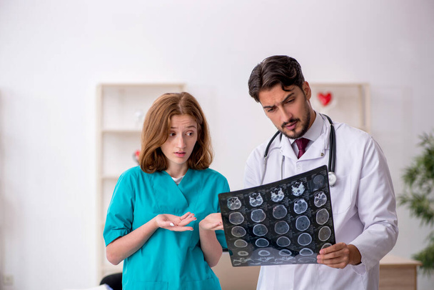 Young male doctor radiologist and female assistant working in th - 写真・画像