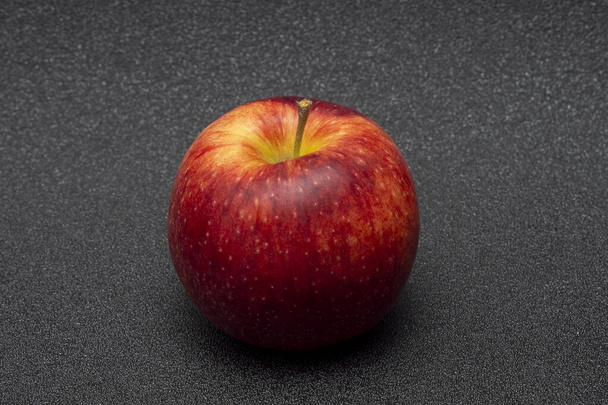 Una manzana roja sobre un fondo oscuro. - Foto, imagen
