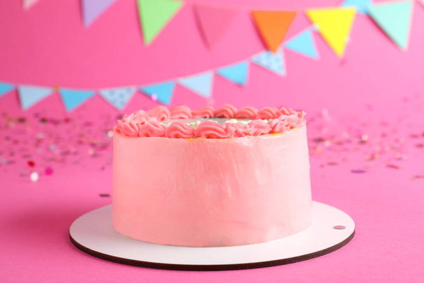 Cute bento cake with tasty cream and decor on pink background - Foto, afbeelding