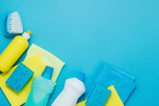 Temizlik seti deterjanları peçeteler sünger eldivenler, mavi arka plan. Ev temizliği ya da temizlik şirketi hizmetleri kavramı - Fotoğraf, Görsel