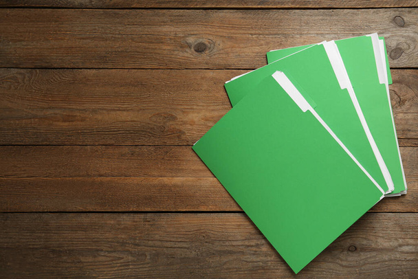 Archivos de color verde claro con documentos en la mesa de madera, vista superior. Espacio para texto - Foto, Imagen