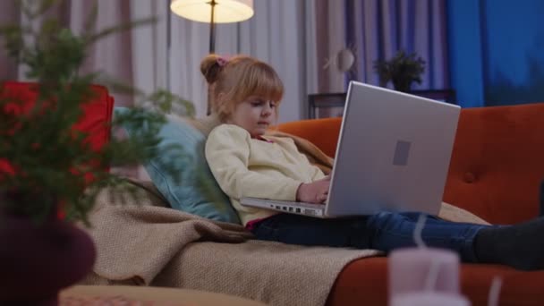 Pieni koulupoika tyttö käyttää kannettavaa tietokonetta oppiminen käsittelyssä verkossa opetuksen oppitunteja yksin kotona - Materiaali, video